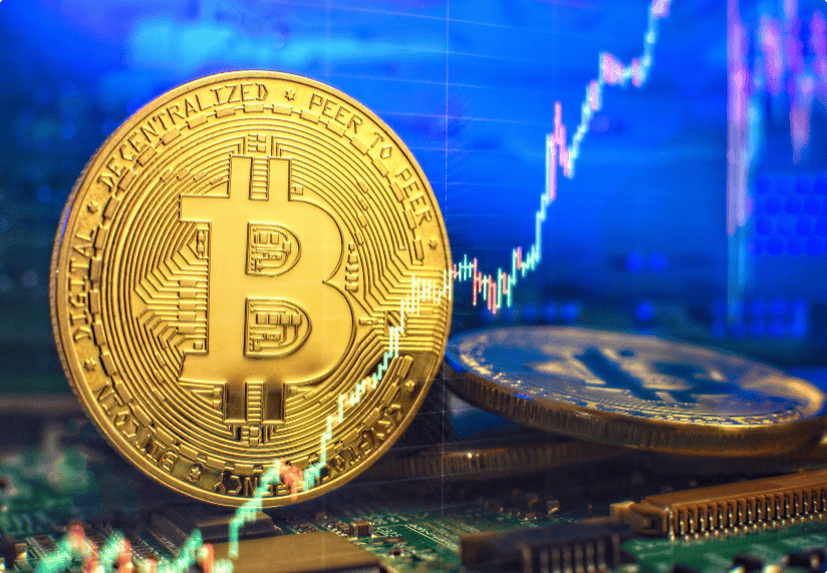 A physical Bitcoin token is placed on a computer circuit board, with a rising cryptocurrency chart displayed in the background.